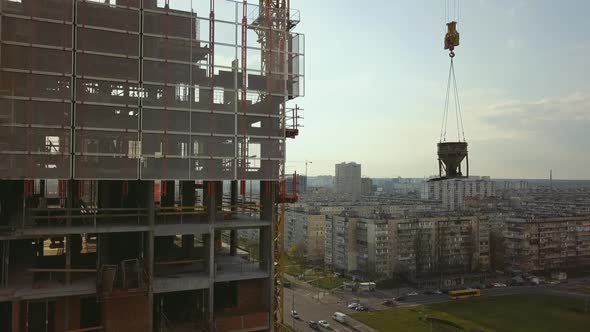 Raising a Cistern with Concrete on the Roof of a Highrise Building Under Construction with Workers