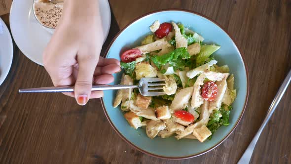 Eating Caesar Salad in a Bowl on Table alt