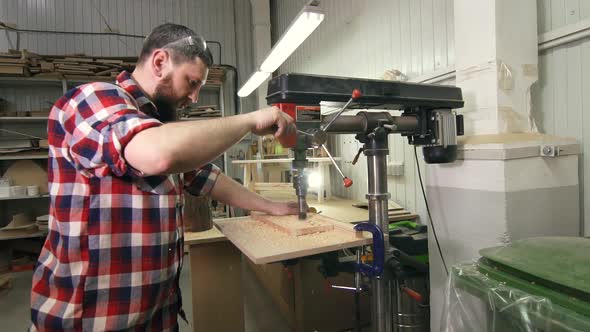 Man Carpenter in a Shirt Using Drilling Machine in Slowmotion alt