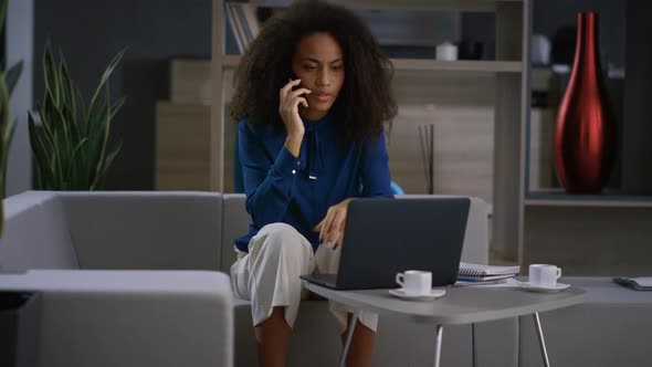 African American Businesswoman Discuss Financial Report By Cell Phone in Office alt