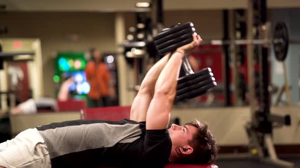 Closeup side shot of bodybuilder adjusting himself to do lying triceps pullover or presses. alt