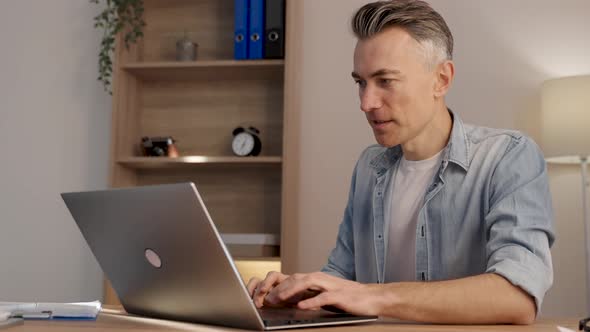 Caucasian businessman or freelancer typing on laptop, working on project, researching