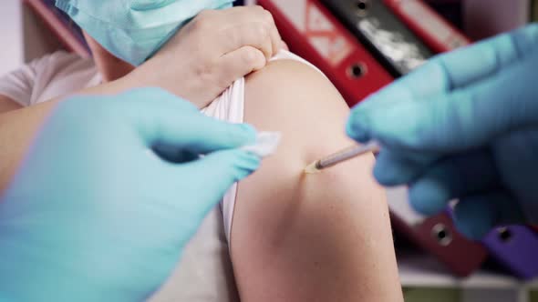 Vaccination passport on the shoulder. A doctor injects a coronavirus vaccine into a woman. alt