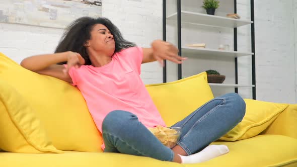 Woman Having Fun at Home. Sitting on The Sofa and Funny Dancing.