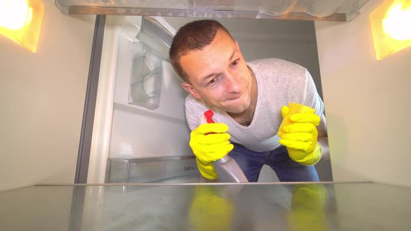 a man opens the refrigerator door, looks inside, he screams, crazy, cleaning. alt