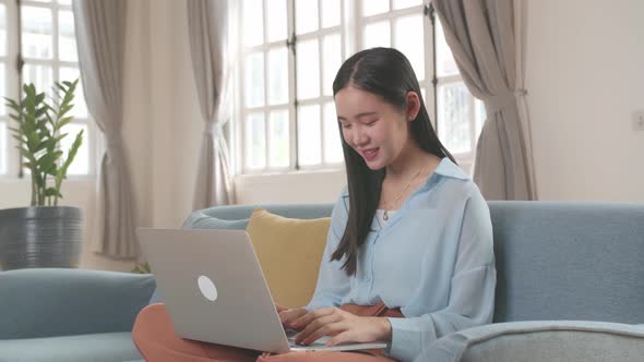 Woman Sitting Sofa And Use Laptop Computer In Living Room alt