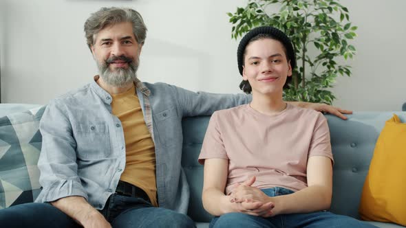 Portrait of Happy Family Father and Teenage Son Sitting at Home Smiling Looking at Camera alt