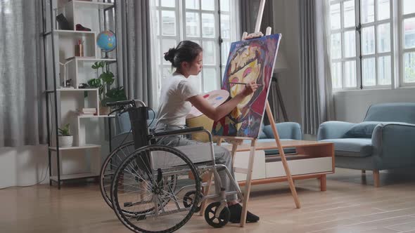 Artist Girl In Wheelchair Holding Paintbrush Mixed Colour Thinking And Painting A Girl On The Canvas alt
