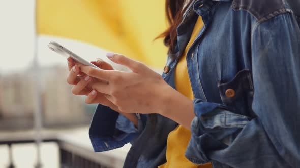 Closeup hand beautiful young Asian girl using smartphone texting messenger at outdoors.