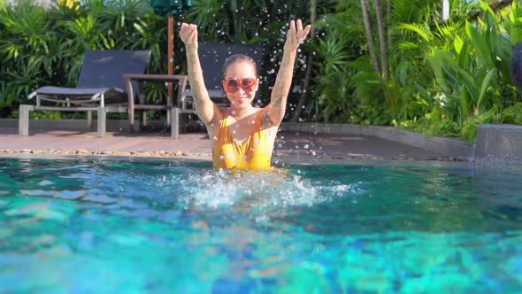 Young asian woman enjoy around outdoor swimming pool for leisure alt