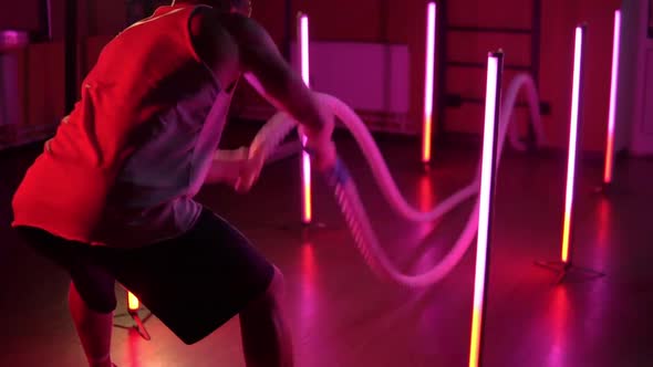 A Young Man Does Exercises with Ropes