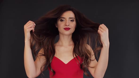 Beautiful Brunette Girl Holding Her Long Hair in Both Hands alt