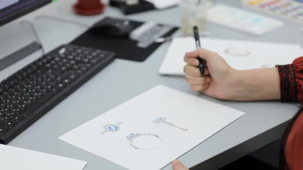 woman designer draws a sketch for jewelry alt