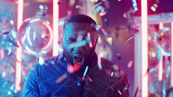 African American Guy Having Fun on Neon Background. Man Clapping Hands in Club alt