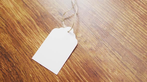 Video of white gift tag with copy space and string on wooden background alt