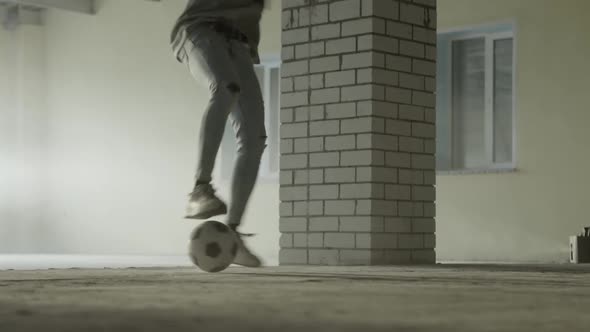 Young Black Guy Trains with a Soccer Ball at Indoors Dribbling Closeup of Foots
