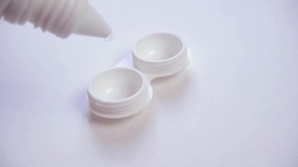 Lens Storage Solution is Poured Into a Plastic Lens Container alt