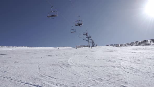 People on chairlift upping on snow mountain alt