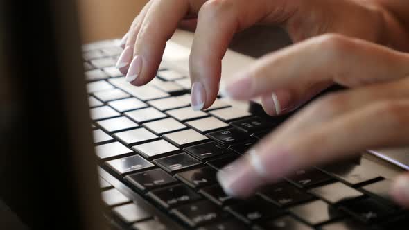 Typing on black laptop PC  keyboard keys woman in office  slow tilting 4K 2160p 30fps UltraHD video 