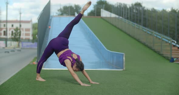 Athletic Woman Does Stretching Exercises, Warm-up Training in the Yard of an Apartment Building alt