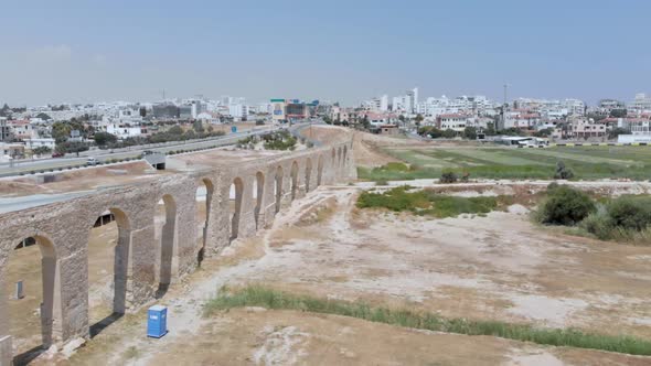 Aerial drone shot travelling over the Kamares Aqueduct arches of Larnaca towards town alt