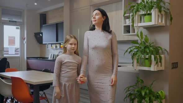 Confident Woman and Girl Holding Hands Walking in Expensive Furniture Store Looking Around Talking alt
