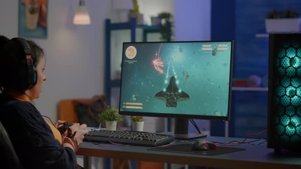 Addicted Lady Playing Space Shooter Video Game Using Headphones alt