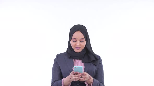 Happy Young African Muslim Businesswoman Using Phone and Looking Surprised alt