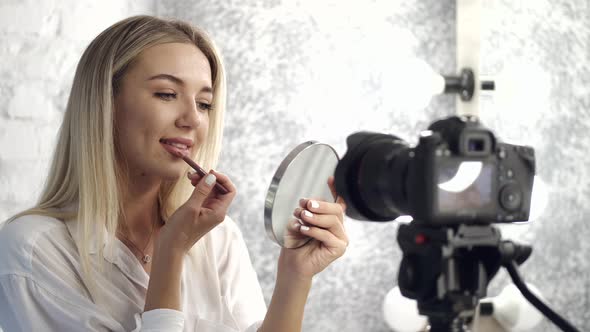 A Pretty Makeup Artist Is Applying Lipliner on Her Lips Looking in a Mirror alt
