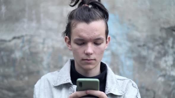 Young Teenager Reads Messages on His Phone