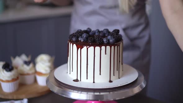 Young lovely woman pastry chef preparing birthday cake at home in kitchen