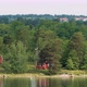 Many Red Swedish Wooden Sauna Logs Cabins Houses On Island Coast In Summer Cloudy Day - VideoHive Item for Sale
