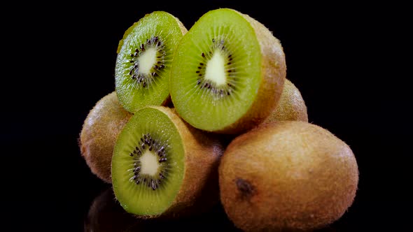 Kiwi fruit rotating on a black background in 4K. Close up of fresh and tasty kiwi