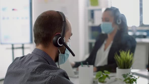 Business Team Wearing Protective Face Masks and Headphone alt