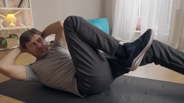 Live Camera Concentrated Sportsman Training Belly Muscles Lying on Exercise Mat in Living Room alt