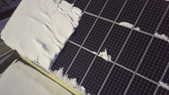 Closeup surface on a house roof covered with solar panels in winter with snow on top. alt