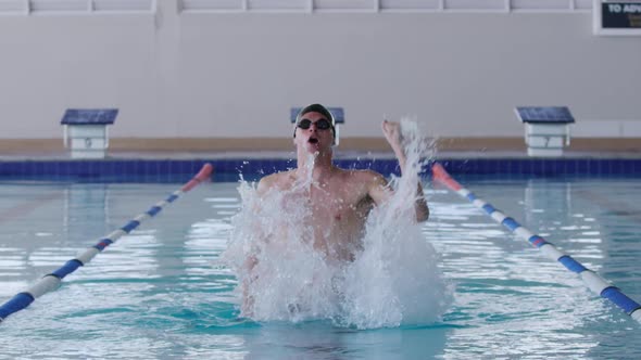 Swimmer coming out of the water and raising arm alt