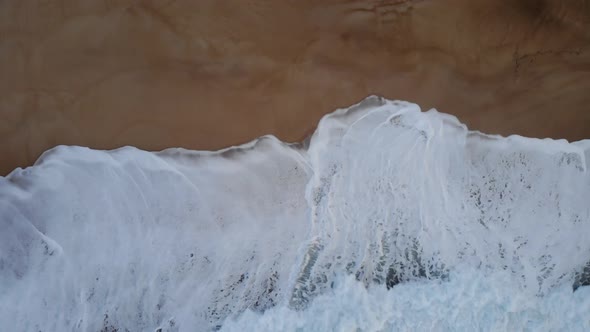 White Foam Waves Over Sandy Beach