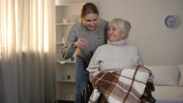 Female Volunteer Gently Covering With Plaid Old Handicapped Woman alt