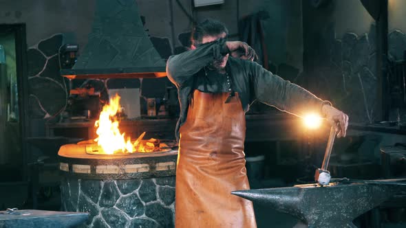 Man Rests Near Anvil at a Forge alt