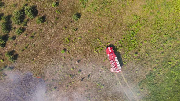 A Fire Engine Shrouded in Smoke From a Fire in a Field alt