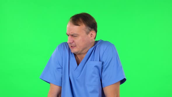 Medical Man Froze and Trying To Keep Warm Against Green Screen. alt