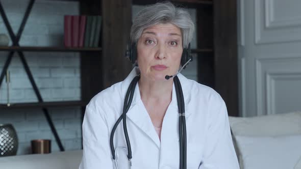 Older Woman Doctor Therapist Wearing Headset Video Call Talking To Web Camera Consulting Virtual alt