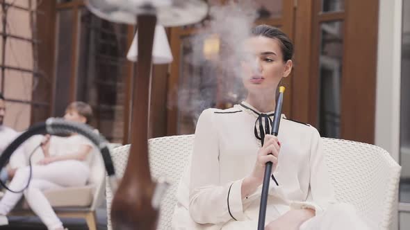 Shisha Bar. Beautiful Woman Smoking Hookah At Restaurant Lounge alt