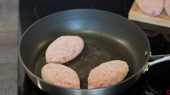 Cutlet in a Pan the Beginning of the Cooking Process alt