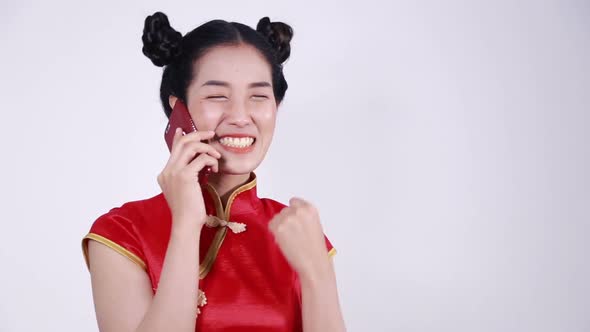 happy woman wear cheongsam and using mobile phone alt