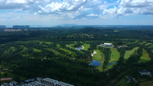 Wide shots of a landscape with housing and blue , cloudy sky. alt