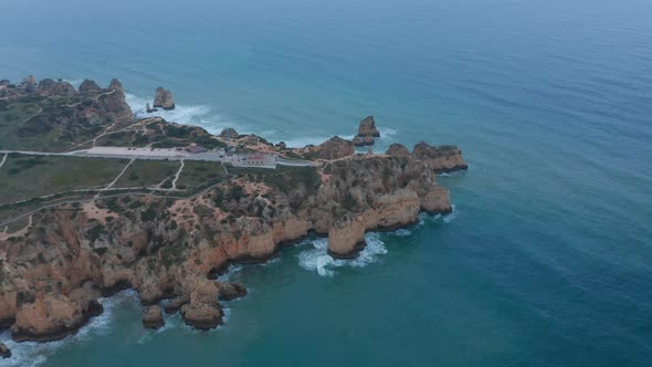 Scenic Background Aerial Drone View of Lagos Rocky Coastline with Lighthouse on Edge Portugal Flying alt