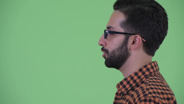 Closeup Profile View of Happy Young Bearded Persian Hipster Man Talking alt