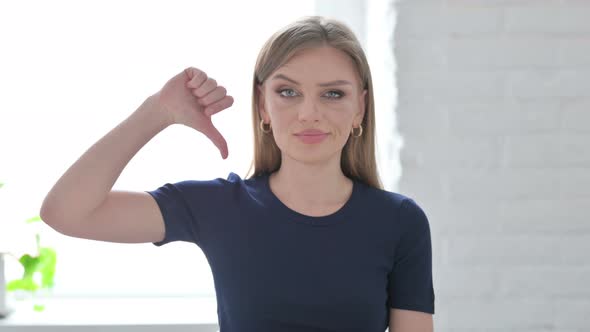 Portrait of Woman Showing Thumbs Down Gesture alt